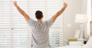 Man wakes up early and stretches before starting his day
